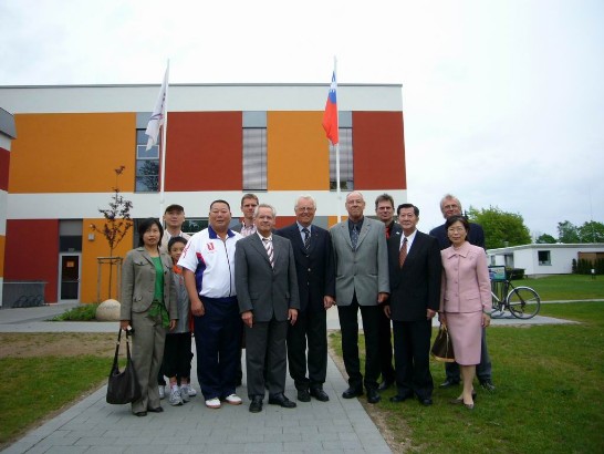 中華民國田徑協會黃副理事長忠仁（右前二）率團應什霍邦田徑協會邀請赴什霍邦訪問，雙方人員於Malente市「什霍邦體育教學中心」我國旗前合影。本處陳處長（右前一）、游秘書（左前一）、什霍邦體育協會副理事長Lindstedt（前排中）、什霍邦田徑協會理事長Delfs（左前三）及交流計畫負責人Schmidt（右前三）960513