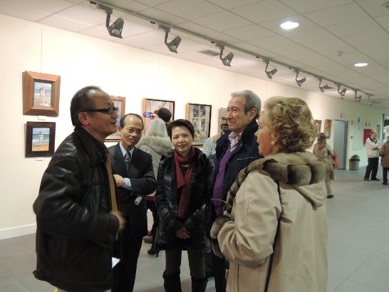 在胡文賢畫展開幕中與西班牙愛好藝術同好談論胡之畫作