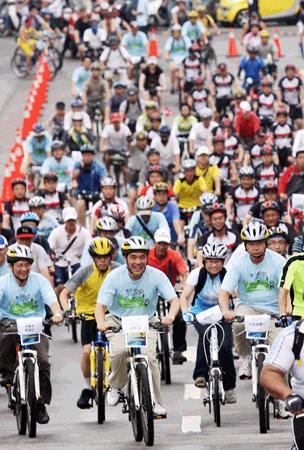 El alcalde de la ciudad de Taipei, Hau Lung-bin (centro), encabeza una columna de más de tres mil ciclistas en el Parque Ribereño Meiti, del sector de Neihu en la ciudad capital, para iniciar un recorrido de doce kilómetros hasta el centro de compras en la avenida Zhongxiao Este. El evento, realizado el 19 del presente mes, fue para conmemorar el Día Mundial sin Autos, que se realizó en Taipei por octavo año consecutivo. El área de Zhongxiao, una de los más concurridas en la ciudad, fue cerrada al tránsito vehicular, al igual que muchos sectores en Taiwan, usualmente congestionados por automóviles. A través de los años, esta actividad de protección medioambiental ha ganado cada vez mayor apoyo de los ciudadanos en la isla. (Foto de CNA) 