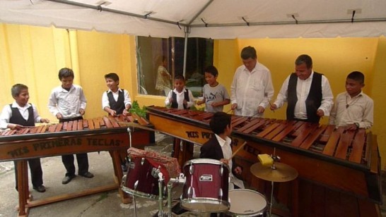 El Embajador Sun tocando marimba con el grupo musical.