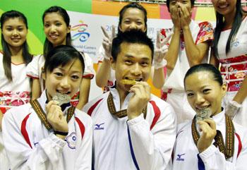 Los taiwaneses Peng Wei-Chua (centro) ganador de medalla de oro, y los medallistas de plata Chen Shao-chi (a la derecha), y Fan Man-yuan muestran las medallas que ganaron en distintas competencias de Wushu Taolu en los Juegos Mundiales de Kaoshiung, el 24 de julio. Es una tradición en Taiwán que los medallistas muerdan sus medallas para comprobar que sí están hechas de puro oro, plata o bronce.