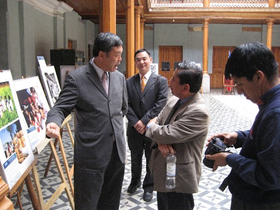 (Quetzaltenango省省政府大廳) 駐瓜國孫大使大成(左)向瓜國專欄作家Jorge Rodríguez(右二)及前往採訪之記者(右一)，逐一介紹我國「建國一百年影像展」各展陳照片之內容。