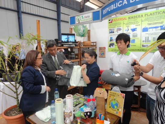 社會發展部長賴英費思達（左一）於本館展攤聆聽孫大使解說慈濟環保毛毯等產品