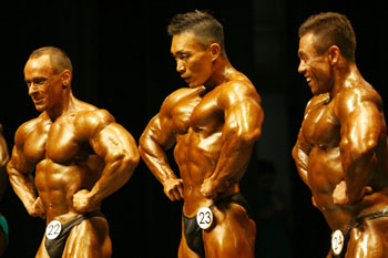 高雄世運男子75公斤級健美賽，18日在文化中心至德堂進行，其中地主隊台灣選手黃建智（中），一出場全場加油聲不斷，表現亮眼。