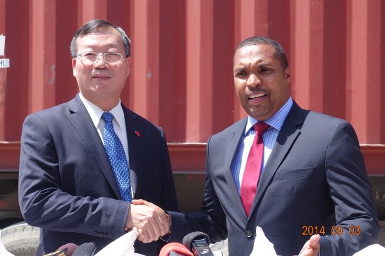 駐海地黃再求大使與社會部長Charles JEAN JACQUES於我政府贈海食米貨櫃前合影。