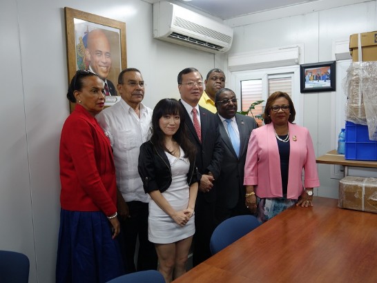 黃大使(中)、衛生部長吉庸(Florence Duperval Guillaume)女士(右一)與衛生部主要官員於所購器材前合影。
