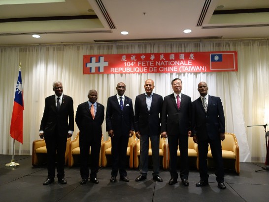 駐海地黃大使再求(右2)於中華民國建國104年國慶酒會中與海地總統馬德立(Michel Joseph Martelly)(右3)、總理保羅(Evans Paul)(左3)、海地國會議長黎榭（Andis Riché）(左2)、最高法院院長兼司法最高委員會主席康大福（Jules Contave）(右1)及外交部國務員史戴林（Henri Robert Sterlin）(左1)等人合影。