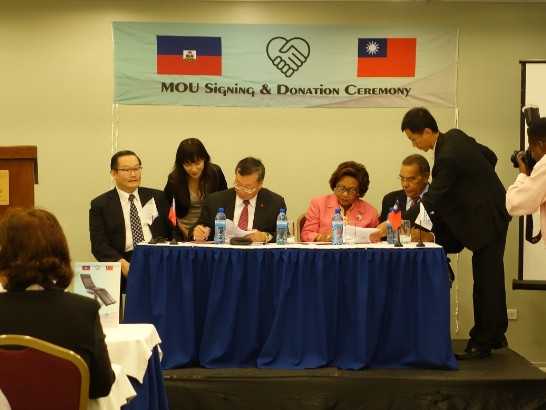 駐海地大使黃再求(左三)及海地衛生部長吉庸（Florence Duperval Guillaume）(右三)見證義大醫院院長杜元坤(左一)與海地Notre Dame Perpetuels Secours（NDPS）醫院院長Rudolph Magloire(右二)簽署合作協議。