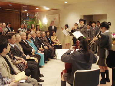 　台中市私立新民高級中学（高校）の生徒１７名は、音楽を通して台日文化交流を促進すると共に、日本に住む台湾人僑胞を慰問するため来日し、東京都内四カ所で四重奏ならびに男女混声合唱によるコンサートを開催した。５月２６日には、台北駐日経済文化代表処の公邸でもコンサートを開いた。このコンサートには許世楷・駐日代表（写真左四）、盧千恵・駐日代表夫人（写真左三）、羅坤燦・副代表（写真左二）をはじめ、代表処の職員や職員の夫人などで組織されている「東京フォルモサ婦人会」のメンバー、代表処職員および各招待客などが出席する中で行われた。（写真左五は劉昭恵・同校理事長、左六は荘弘雄・同校校長）