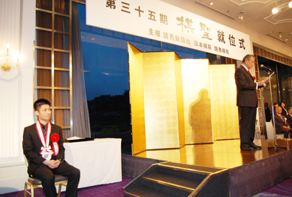 ３月１１日に行われた第３５期棋聖戦７番勝負の第６局で、挑戦者の井山裕太・九段を制し、シリーズ通算成績４勝２敗で初防衛を果たした台湾出身の囲碁棋士、張栩・棋聖（写真左１）の就位式が、４月１９日に東京都内のホテルで、読売新聞社、日本棋院、関西棋院の主催により開催された。台北駐日経済文化代表処の馮寄台・駐日代表（左２）は来賓祝辞の中で、「私が日本に代表として着任してから張栩さんの各種タイトル就位式に出席するのは今回で１１回目となる」と強調した。また、今回の東日本大震災についても言及し、「我々台湾人は日本の痛みを深く感じている。私は台湾の政府と国民を代表し、日本の早期の復興を祈っている」と述べた。張栩・棋聖も謝辞の中で「今、日本全体が苦しい局面にある中で、心折れずに一人一人が自分の役割で最善を尽くすことができれば、きっと良くなると信じていく気持ちが大事だと思う。今回の棋聖戦の賞金の三分の一の額（１，５００万円）を震災の義援金として寄付することに決めた」と述べ、会場から大きな拍手が沸いた。さらに、「囲碁は日本のすばらしい文化であり、どんな時代にあっても人の心を豊かにできるものだと信じている。これからも囲碁棋士という職業に誇りを持ち、魂を込めて良い対局をし、囲碁界から少しでも明るいニュースを発信できるよう精進していきたい」と謙虚に抱負を語った。