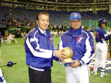 ３月５日に開幕する「ワールド・ベースボール・クラシック」（ＷＢＣ）に出場するため来日している野球台湾代表チームを激励するため、馮寄台・台北駐日経済文化代表処代表（左）は３月２日午後、東京ドームを訪れ、試合に先立ち練習に励む選手らに日本のリンゴを贈り、選手らを慰労した。葉志仙・台湾代表チーム監督（右）は、チームのスタジアムジャンパーと選手らのサイン入り特製ボールを馮代表に贈った。ＷＢＣ東京ラウンドは台湾、日本、中国大陸、韓国の４チームが対戦し、台湾は６日に韓国と試合を行う。ＷＢＣ第１ラウンドは３月９日まで開催され、上位２チームが３月１５日から米国で行われる第２ラウンドに出場する。