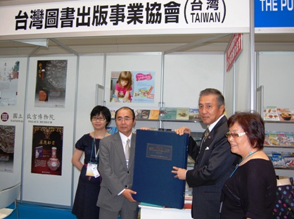 「第１６回東京国際ブックフェア」が７月９日、東京有明の東京ビッグサイトで開幕した。同展は世界３０カ国から約８００社が参加するアジア最大級の出版界イベントであり、今回台湾からは「台湾図書出版事業協会」および「台湾華語文産業推動連盟」の２つのブースが設けられ、台湾の書籍をアピールした。今回、中華民国図書出版事業協会から日本の拓殖大学フォルモサ図書室に国史館台湾文献館および南天書局が共同でまとめた『日本統治時代の台湾都市発展地図集』が寄贈されることになり、台湾ブース前で贈呈式が行われた。台湾側を代表して台北駐日経済文化代表処の馮寄台・駐日代表（左３）から重さ２０キロの同地図集が拓殖大学の岸澤輝明・国際部長（左２）へと手渡された。
