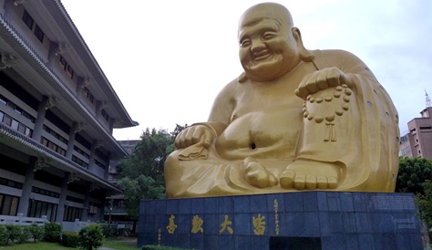 台中市のシンボル的存在として親しまれている大きな布袋様。ここは1927年に創建された臨済宗の寺院です。正式名称は｢寶覚禅寺｣。もともとは黒い瓦屋根を冠した本堂が建っていましたが、老朽化が進んだため、数年前に修復工事が施されました。歴史建築を保護するという名目で本殿は残され、原形を保っていますが、これを大きく覆うように新しい本堂が建てられています。その先に進んでいくと、高さ30メートルという巨大な彌勒大仏があります。これはいわゆる布袋様で、完成は1969年。全身が黄金色に輝き、愛嬌に満ちた表情をしています。建物の裏にありますが、ここを訪れたら、忘れずに布袋様にご挨拶をし、道中の安全を祈願したいものです。台中を訪れた行楽客はこれをバックに記念撮影するのが定番となっています。