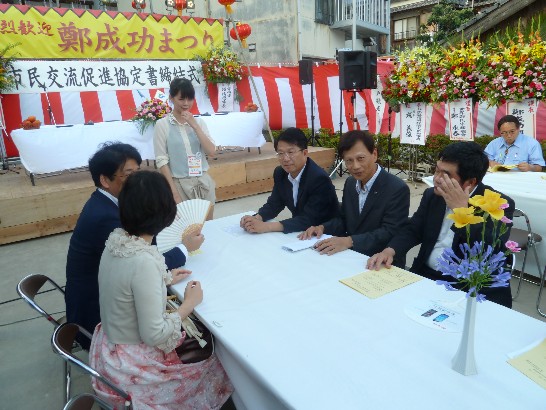 黒田市長夫妻と台南市顔副市長が開会前に意見交換をした時戎総領事が通訳