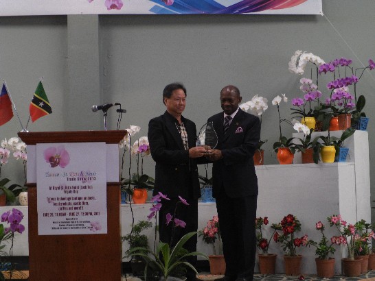 貿訪團台商廖總裁金德致贈水晶獎座予克國道格拉斯總理。