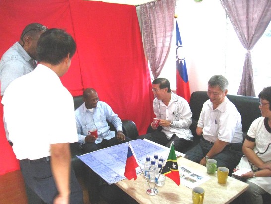 道總理(左三)參觀計畫辦公室(原農技團團部舊址)，葉經理(左二)及克方計畫協調人Andy Blanchette(左一)分別以實景照片及建物藍圖向道總理及曹大使(右三)說明計畫進度，訪克之中興大學唐立正教授(右二)及農委會周桃美副研究員(右一)等在座。