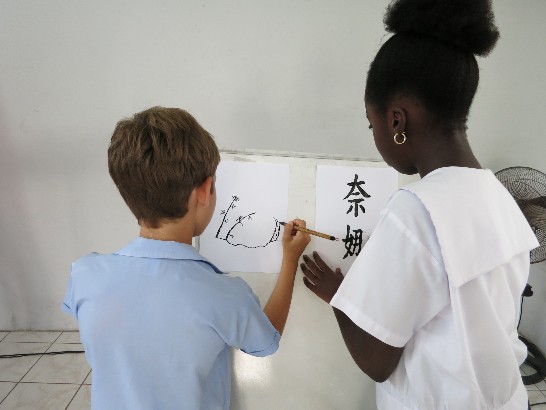 學生Conor Taylor(左)及Nana Gymah分別揮毫展現書法及水墨畫成果。