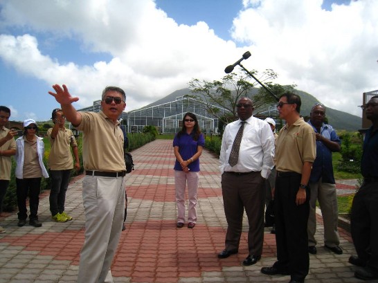 【圖二】國合會計畫經理林福泉（前排左一）向克國總理哈里斯(Timothy HARRIS) （前排右二）介紹新觀光示範農場配置之防猴電網及追日系統