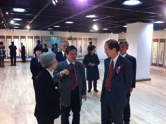 李會長壽德女士(左一)向梁代表(右二)介紹書畫展情形。