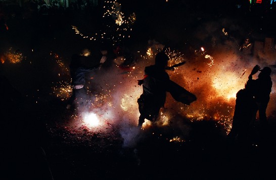 媽祖神轎出巡，漫天炮光，硝煙四溢。神童穿梭其中，祈福求安。（曾騰桂  拍攝）