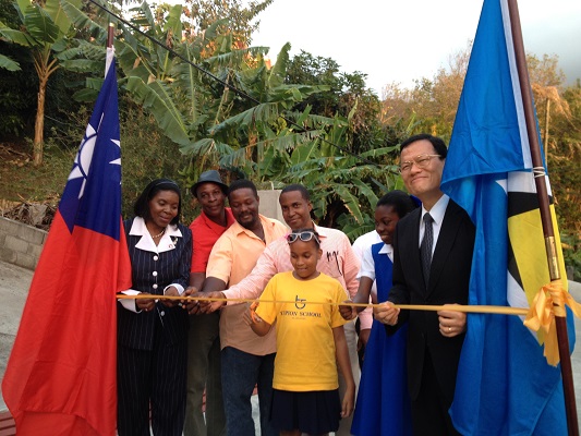 中華民國駐聖露西亞大使章計平(右一)與希波莉(Emma Hippolyte)商務部長(左一)及地方人士代表共同為九重葛道路開通剪彩