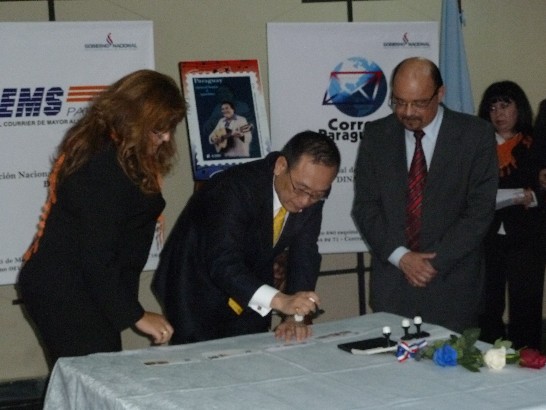 劉大使德立與巴拉圭郵政總局長Angel Pintos（右）於首日封上加蓋慶祝我102年國慶紀念郵戳。