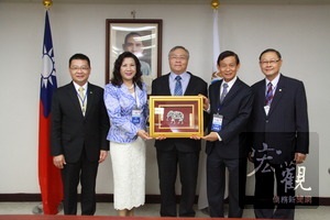 泰國海華協會訪問團團長林來好僑務委員（左二）致贈紀念品給僑務委員會主任秘書張良民（中）