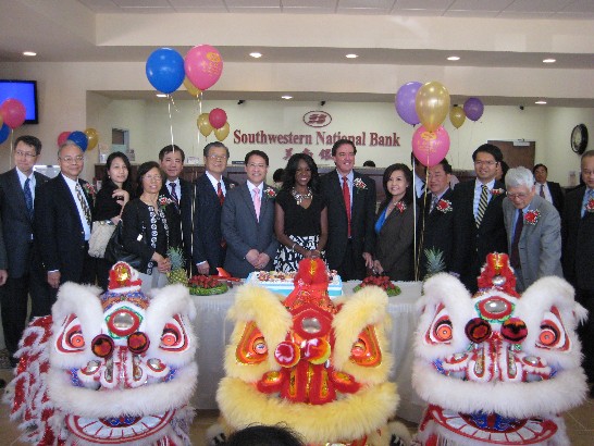 廖東周處長(左七)、糖城代理市長Jacqueline Chaumette (右六)與美南銀行李昭寬董事長(左六)及嘉賓在該行糖城分行喬遷開幕儀式中與祥獅合影