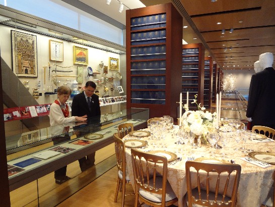 廖處長仔細聆聽圖書館導覽人員介紹館藏展示品。