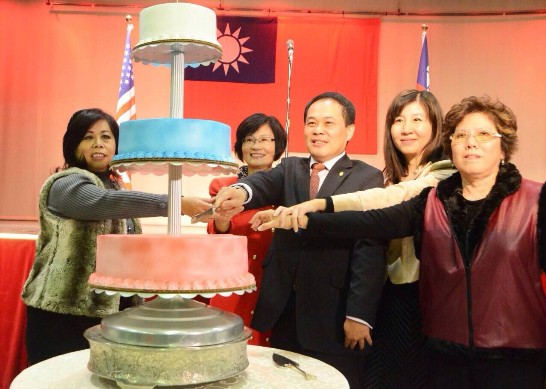 黃敏境處長夫婦與中華公所共同主席張錦娟及甘幼蘋於104年1月1日上午在僑教中心大禮堂舉行元旦升旗典禮之後茶會上合切蛋糕。