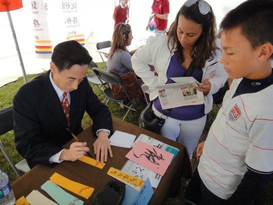 牟處長於佛州第二十二屆亞洲文化節之台灣攤位親自為民眾提字