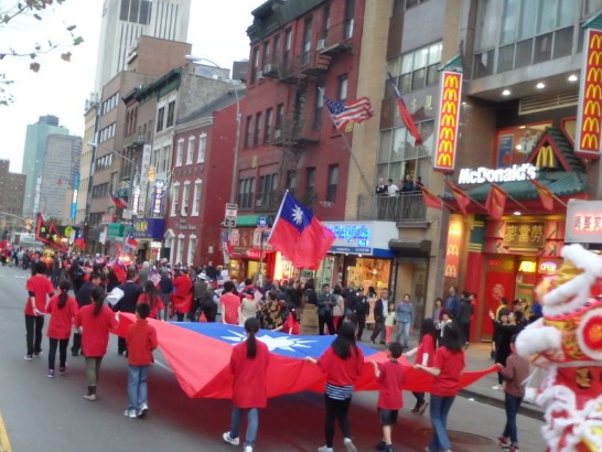 紐約曼哈頓華埠歡慶中華民國103年雙十國慶活動重頭戲就是一年一度的全僑大遊行，巨型中華民國國旗吸引大批市民及外國遊客，觀看並搖旗呼應。