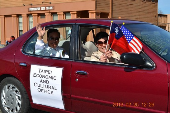 江處長擔任貴賓引導遊行前進，與遊行民眾揮舞國旗致意