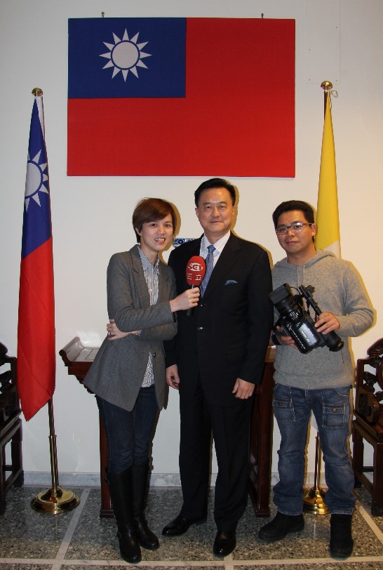 Ambassador Wang (middle) stands between TV reporter Ms. Liao Ya-yu and cameramen Mr. Kuan Pu-lin.