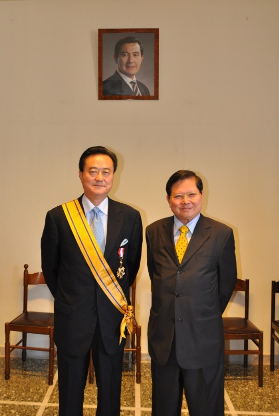 Ambassador Wang, proudly showing his sash and decoration, with Chairman Wu.