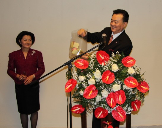 Ambassador Larry Wang shakes the bag containing the lottery tickets.