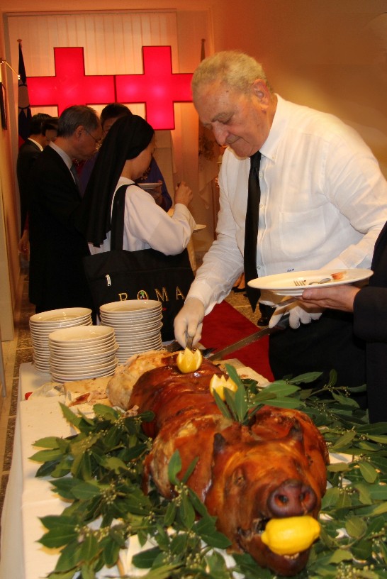 The catering manager serves “porchetta” to the guests.
