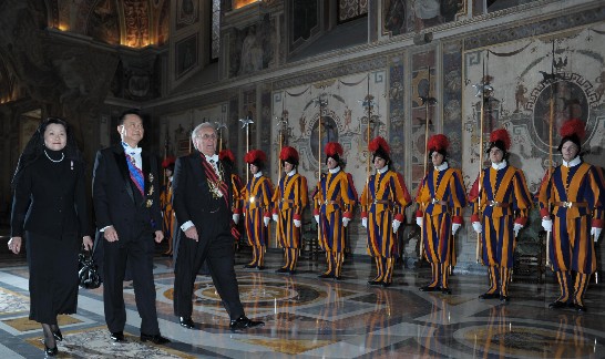 Ambassador and Mrs. Wang are accompanied to the Hall of the Throne by a Gentleman of His Holiness