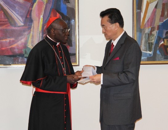 Ambassador Larry Wang (right) delivers the donations to Cardinal Robert Sarah (left) during a ceremony held inside the Pontifical Council “Cor Unum.”