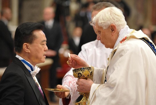 Ambassador Wang is receiving the Holy Communion from the hands of the Pontiff