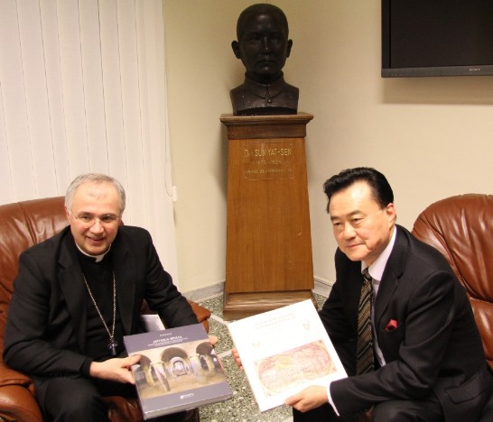 Bishop Claudio Giuliodori and Ambassador Wang hold two books on Macerata history brought by the Bishop.