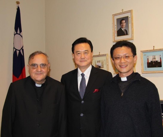 Ambassador Wang （middle） between Fr. Li (1st from right) and Fr. Sanroman (1st from left) posing inside the Chancery next to the ROC’s flag