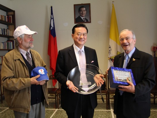 Ambassador Wang (middle) shows the plate given him by Montefortiana Secretary Gianluigi Pasetto（1st from right), while Renato Bicego stands on his left holding a commemorative Camillian cap.