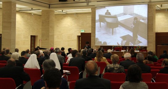 Members of the audience watch the performance from the big screen.