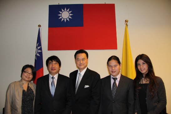 Group picture: Ambassador Wang (middle) with Mr. Chou (2nd from right), Mr. Chang (2nd from left), Ms. Fu-chih Yang (1st from left), and Ms. Tsai-yi Hsieh (1st from right) pose in front of the ROC flag at the Chancery.