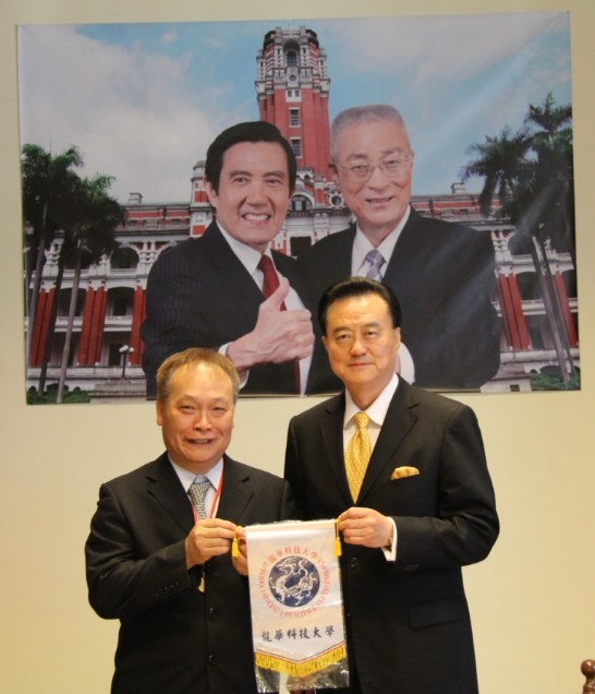 Ambassador Larry Wang (1st from right) shows the banner flag of the Lunghwa University of Science given to him by the Dean of the Management College Chen Yuan-Ho.