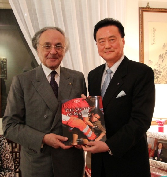 H.E. Jean-Pierre Mazery (1st from left) gives as a gift to Ambassador Larry Wang (1st from right) a book on the history of the Order of Malta.