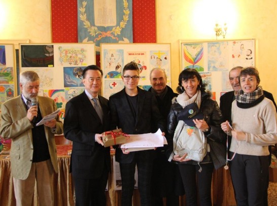 Ambassador Larry Wang (2nd from left) delivers the award to the winner of the Children’s Drawing Contest. Mayour Carlo Tessari stands next to the winning boy. 