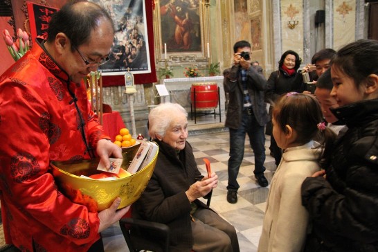 Spanish Sister Carmen Zaballa (seated in the middle) hands out red envelopes to children and youngsters.