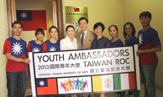 Group picture of Ambassador and Mrs. Larry Wang (5th and 6th from right), with Prof.  Zhao-Shun Zeng (4th from right) and the Youth Ambassadors wearing a shirt with the ROC flag on it outside the door of the ROC Chancery.